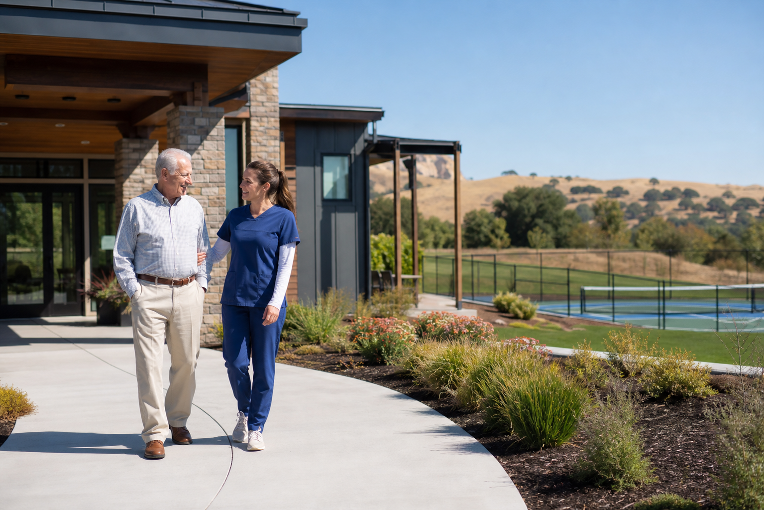 Senior Living Community Walk with Caretaker and Rolling Landscape