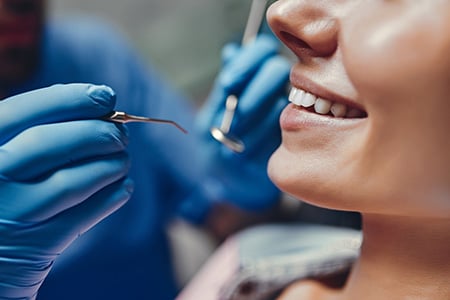 A Dentist Preparing to Clean a Patient's Teeth