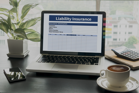 A Laptop on a Desk With a Liability Insurance Claim Form