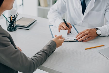 A Doctor Writing A Prescription to a Patient