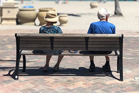 Retirees Sitting at a Bench on the Beach
